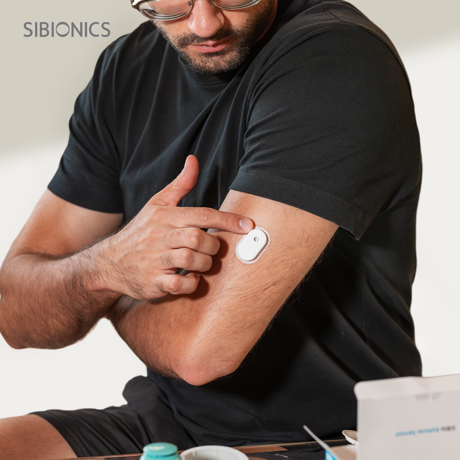 Person med SiBio CGM-sensor festet på overarmen